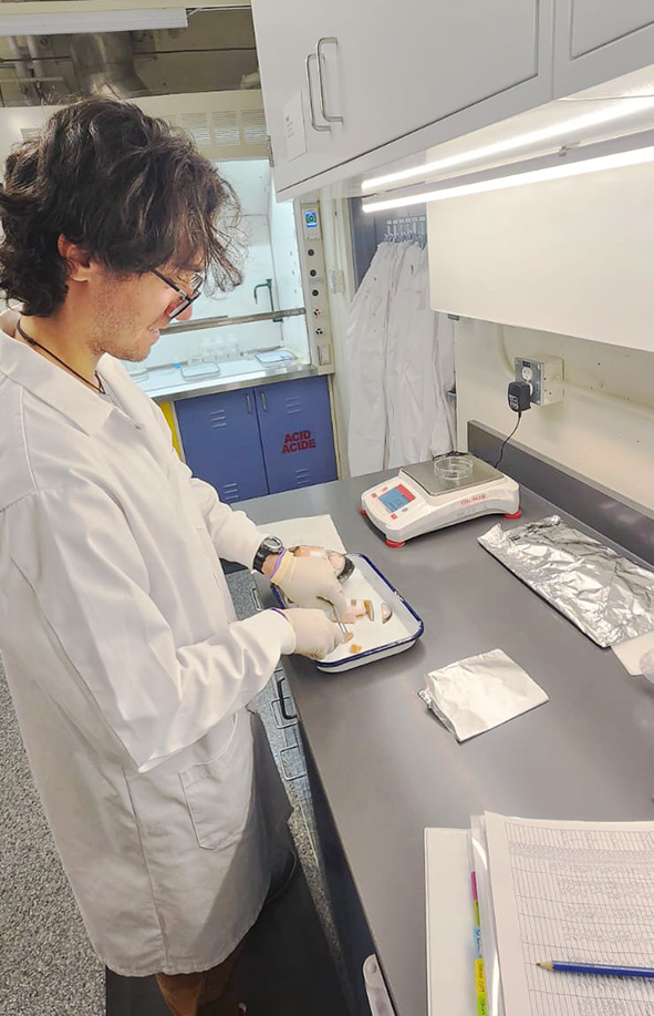 UBC Science Co-op Biolgoy student Elliott Evans dissects fish heads in a lab setting.