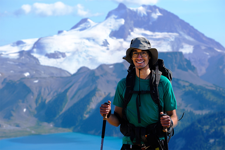 UBC Science Co-op Biology Elliott Evans hiking in the snow-capped British Columbia mountains.