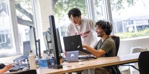 Two students work on a computer together.