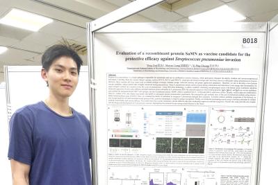 UBC Science Co-op in Microbiology and Immunology student Marcus Liang stands in front of his poster project at a conference.