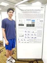 UBC Science Co-op in Microbiology and Immunology student Marcus Liang stands in front of his poster project at a conference.