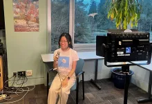 UBC Science Co-op Cognitive Systems (Computational Intelligence and Design) student Rachel Chiu sits in a chair and speaks into a microphone.