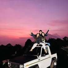 Kwan Ki (Jerry) Wong and two friends in a white vehicle at sunset.