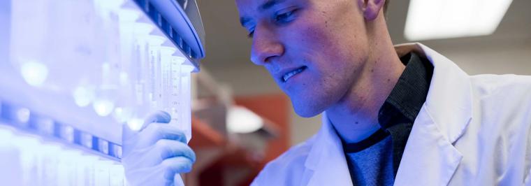A man looks at a test tube.