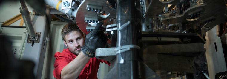 A man works on some mechanical equipment.